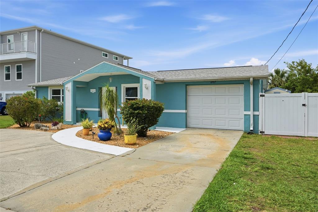 A teal single-story house with a white garage door and a concrete driveway — 6907 CLARK STREET, HUDSON, FL