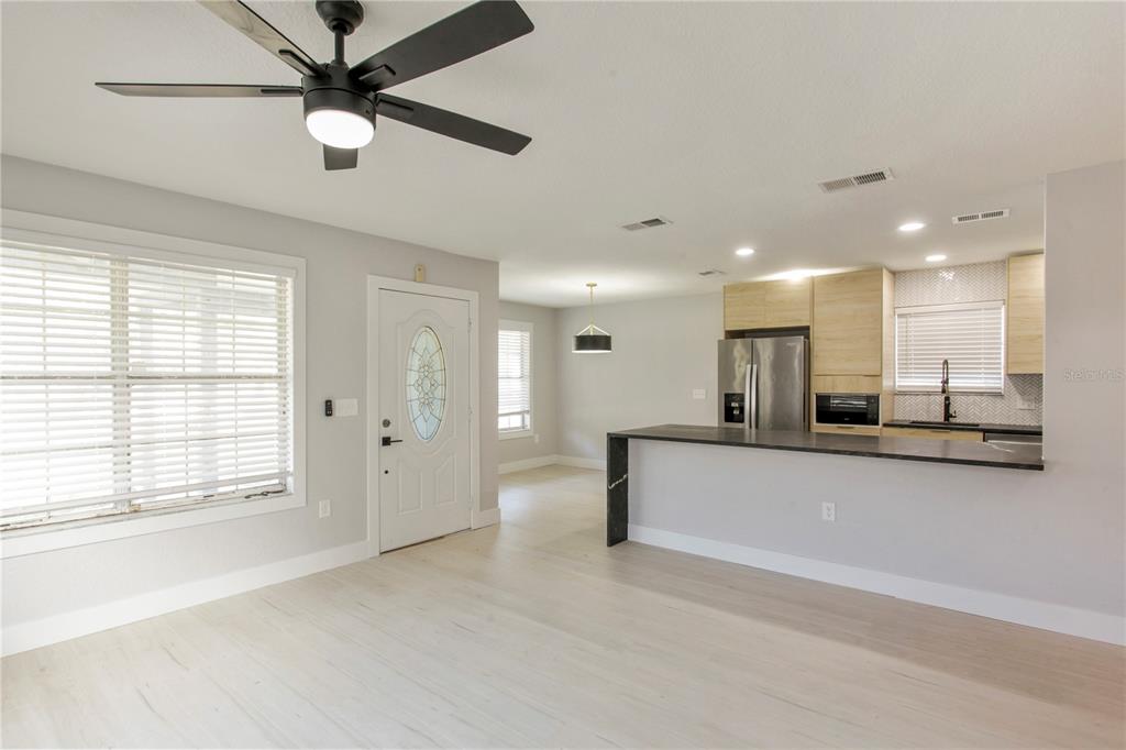 An open-concept living area features light wood flooring, a kitchen island, and a ceiling fan — 822 POLK STREET, ORLANDO, FL