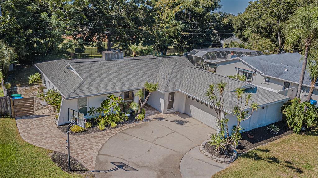 An aerial view of a single-story house with a paved driveway and a basketball hoop — 565 SANDY HOOK ROAD, PALM HARBOR, FL