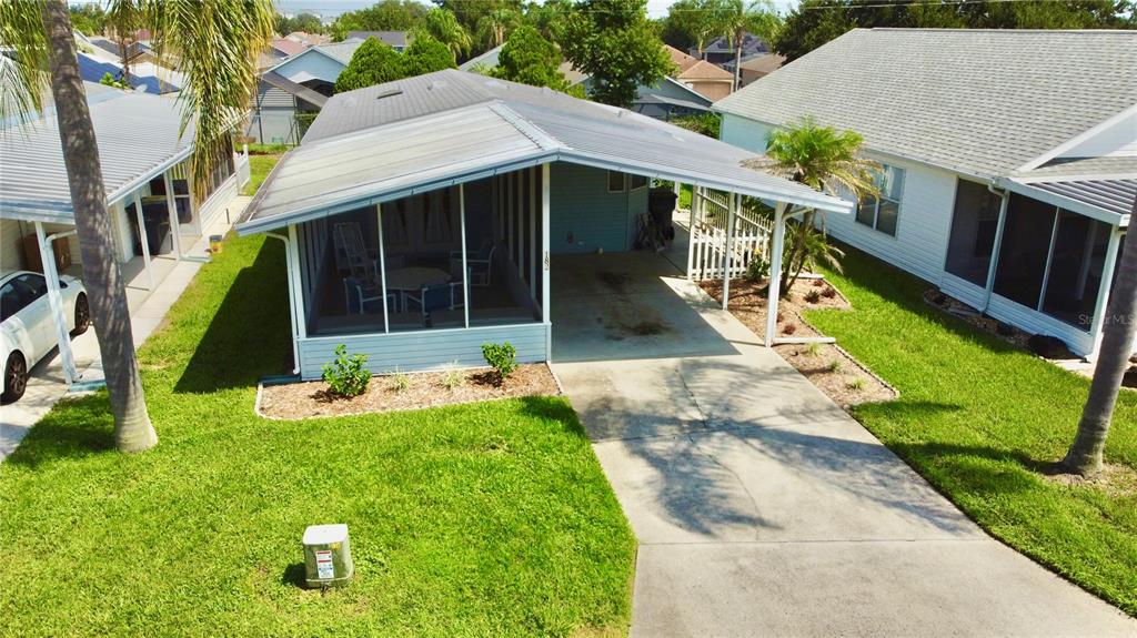 An aerial view of a mobile home with a screened-in porch and a concrete driveway — 50989 HIGHWAY 27 UNIT 182, DAVENPORT, FL