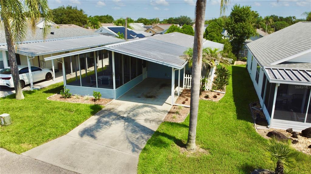 An aerial view of a house with a screened-in porch, carport, and driveway — 50989 HIGHWAY 27 UNIT 182, DAVENPORT, FL