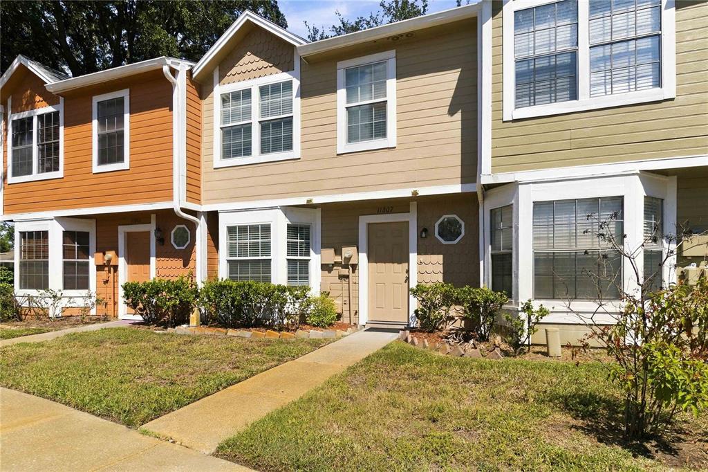 A bedroom features a wooden bed frame, dark flooring, a ceiling fan, and a television — 11807 MINTWOOD COURT, ORLANDO, FL