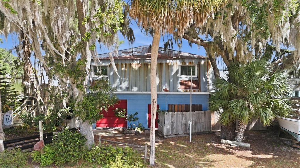 A two-story house with blue siding, a red garage door, and a metal roof — 400 LAKESHORE DRIVE, EUSTIS, FL