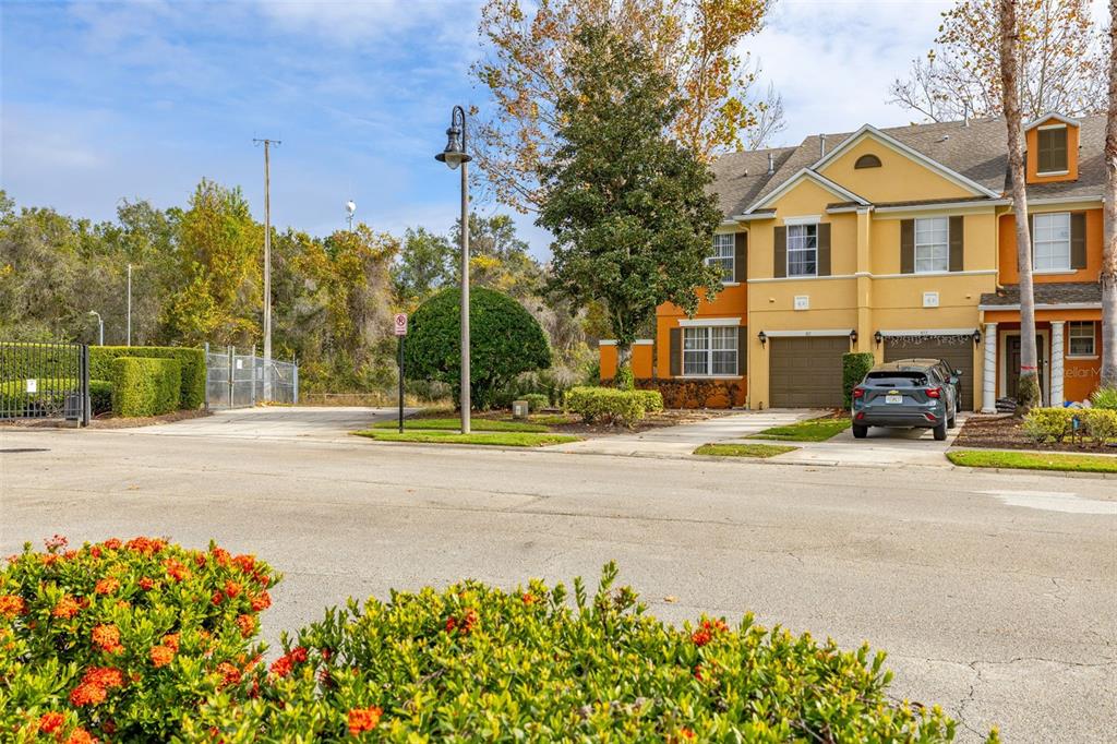 A street view of a two-story townhouse with a driveway and a parked car — 811 ASSEMBLY COURT, REUNION, FL