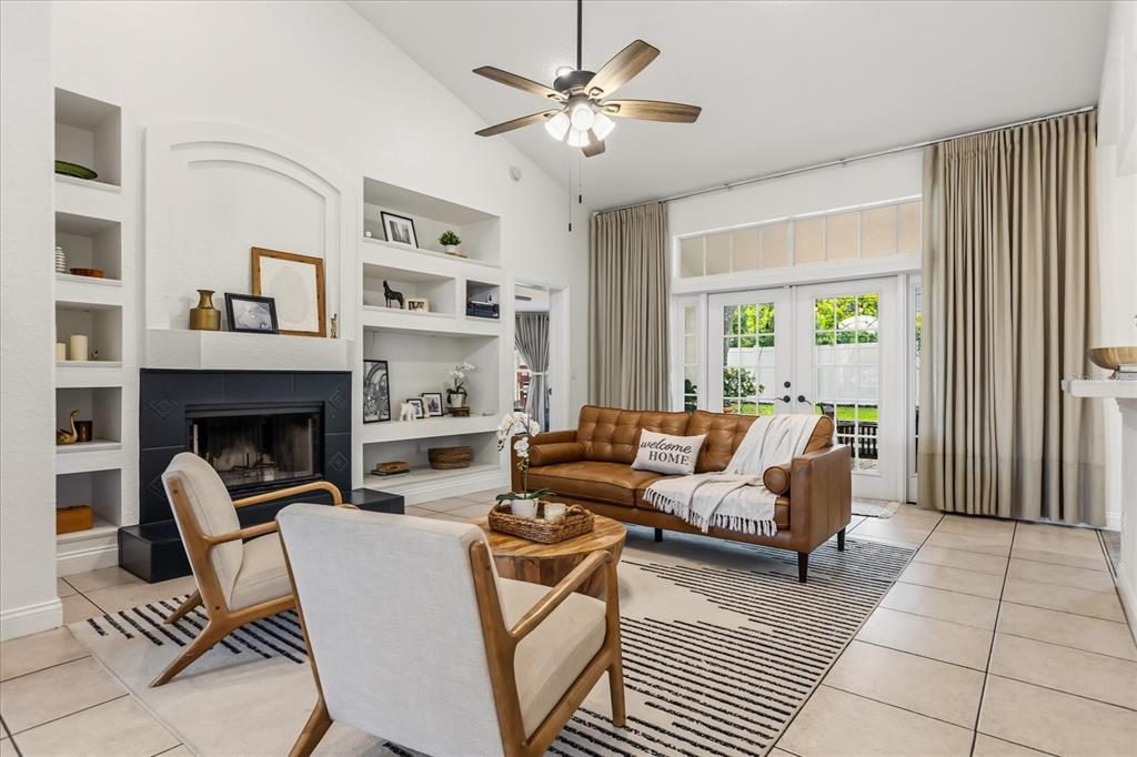 A living room features a fireplace, built-in shelving, a leather sofa, and glass patio doors — 1934 THOROUGHBRED DRIVE, GOTHA, FL