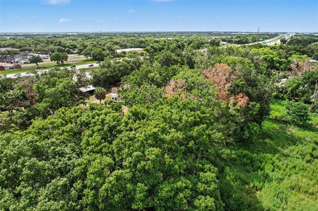 An aerial view shows a wooded lot with a small structure near a paved road — FAIRFIELD AVENUE, BRANDON, FL