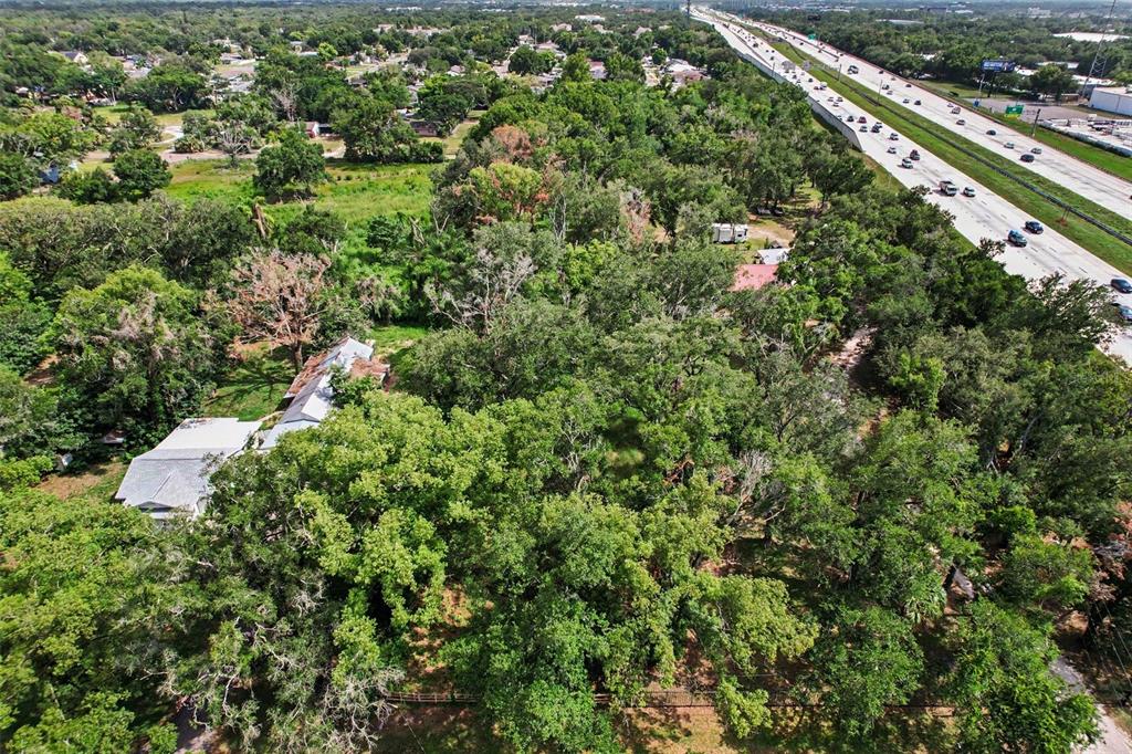 An aerial view shows a wooded lot with a house next to a multi-lane highway — FAIRFIELD AVENUE, BRANDON, FL