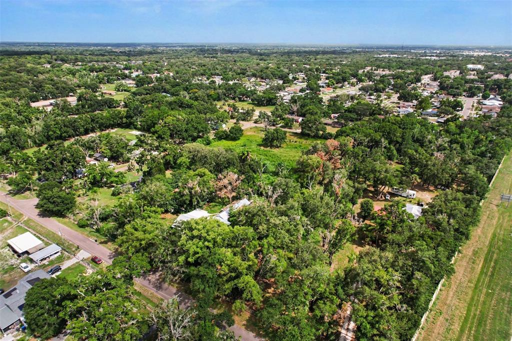 An aerial view shows a wooded residential lot with a house surrounded by dense trees — FAIRFIELD AVENUE, BRANDON, FL