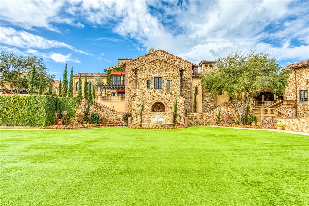 A large stone mansion with a manicured lawn and a central fountain in the backyard — 16748 ARTIMINO LOOP, MONTVERDE, FL