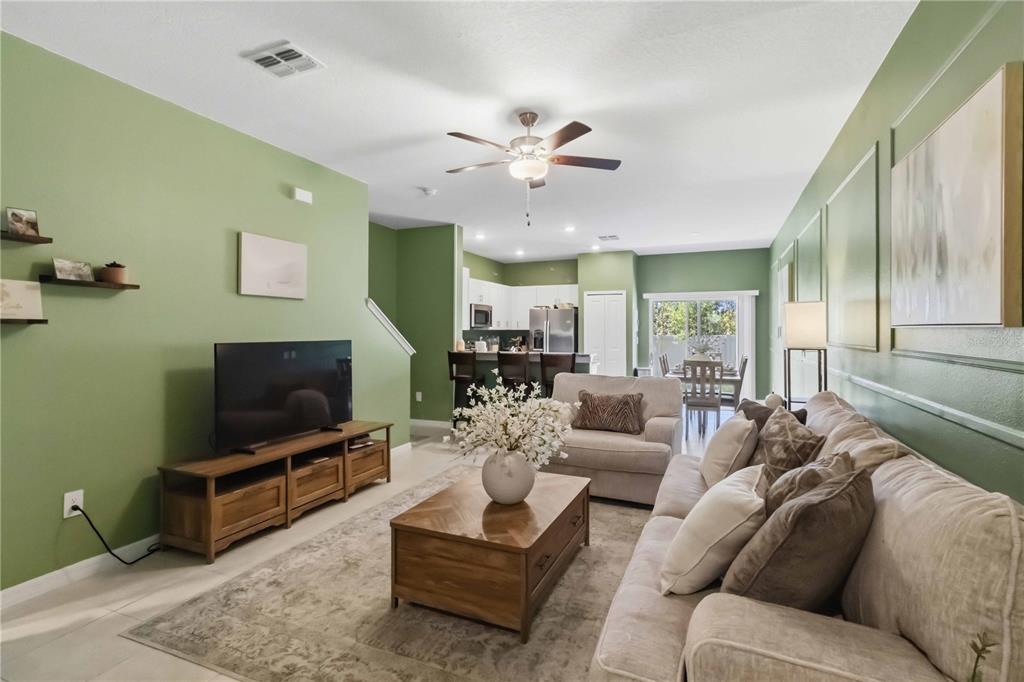 A living room with green walls, a beige sofa, and a wooden coffee table — 2549 SUNRAY VENUS WAY, RUSKIN, FL