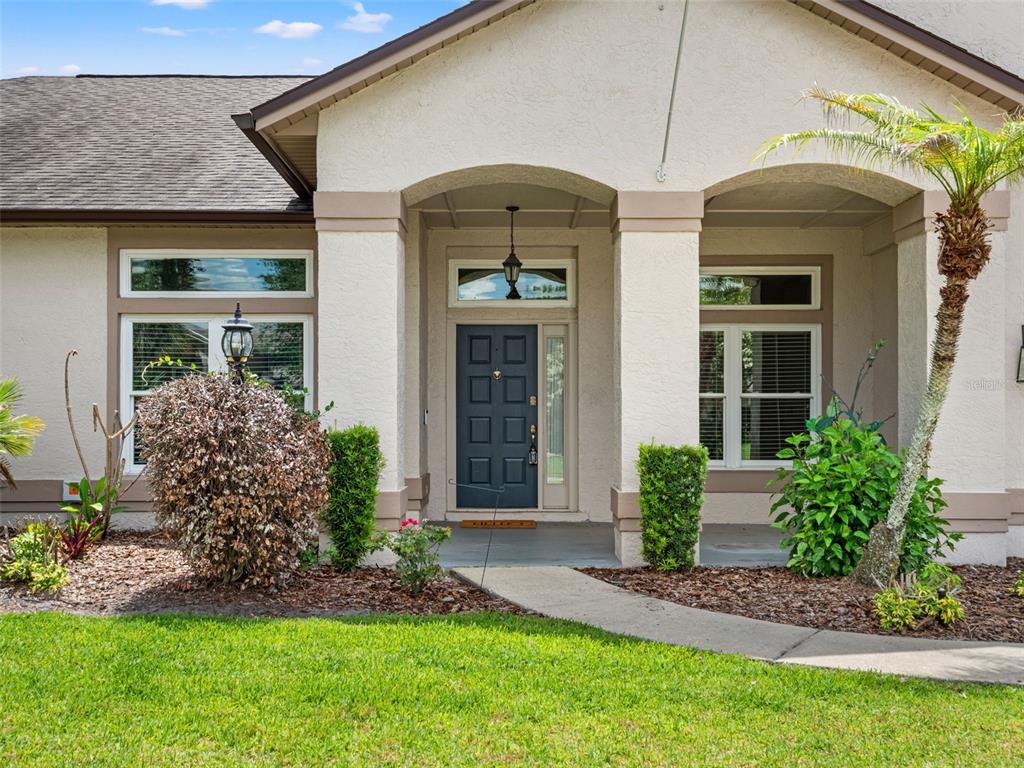 The exterior of a house features a covered entryway with a dark door and columns — 4353 STEED TERRACE, WINTER PARK, FL