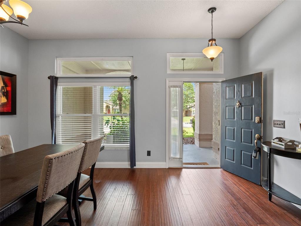 A dining area with wood floors, a dark front door, and a large window — 4353 STEED TERRACE, WINTER PARK, FL