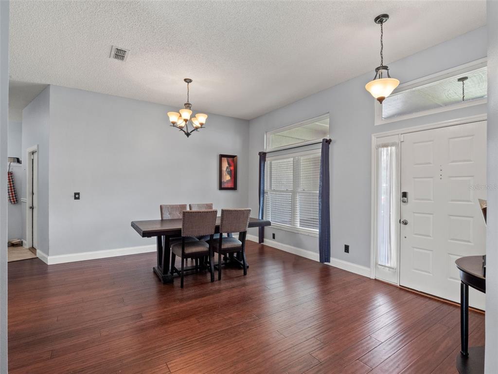 A dining room with hardwood floors, a chandelier, and an entryway door — 4353 STEED TERRACE, WINTER PARK, FL