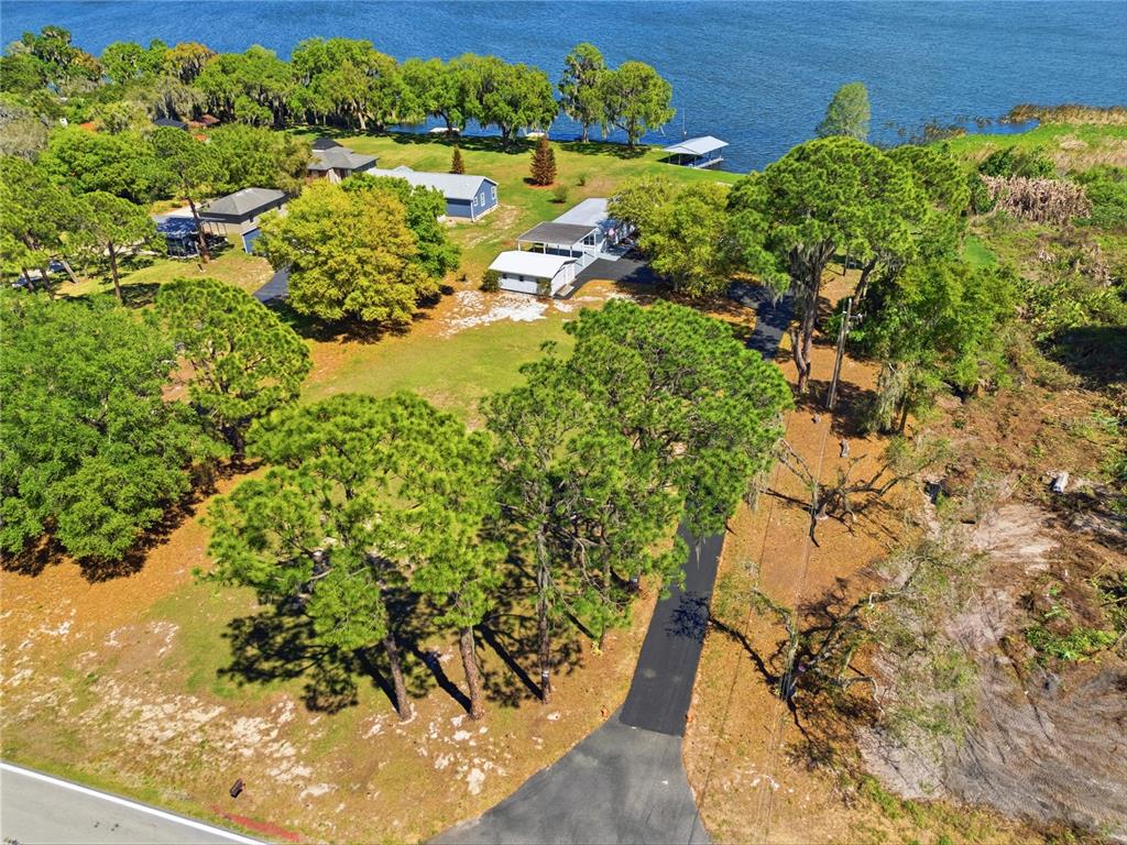 A single-story house with a carport and a large tree in the front yard — 8342 W LAKE MARION ROAD, HAINES CITY, FL