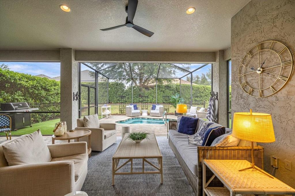 A covered patio features outdoor furniture, a pool, and a large wall clock — 1763 W TWILIGHT LANE, HERNANDO, FL