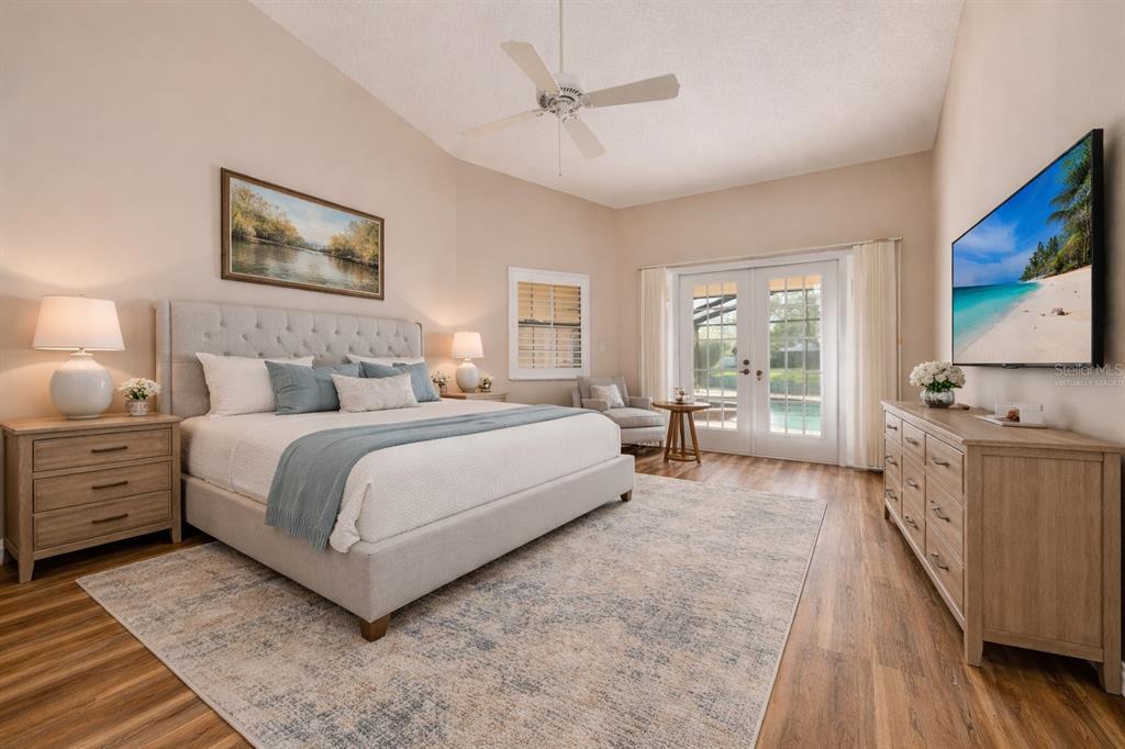 A living room with a fireplace, vaulted ceiling, large sliding glass doors, and pool view — 470 HICKORYNUT AVENUE, OLDSMAR, FL