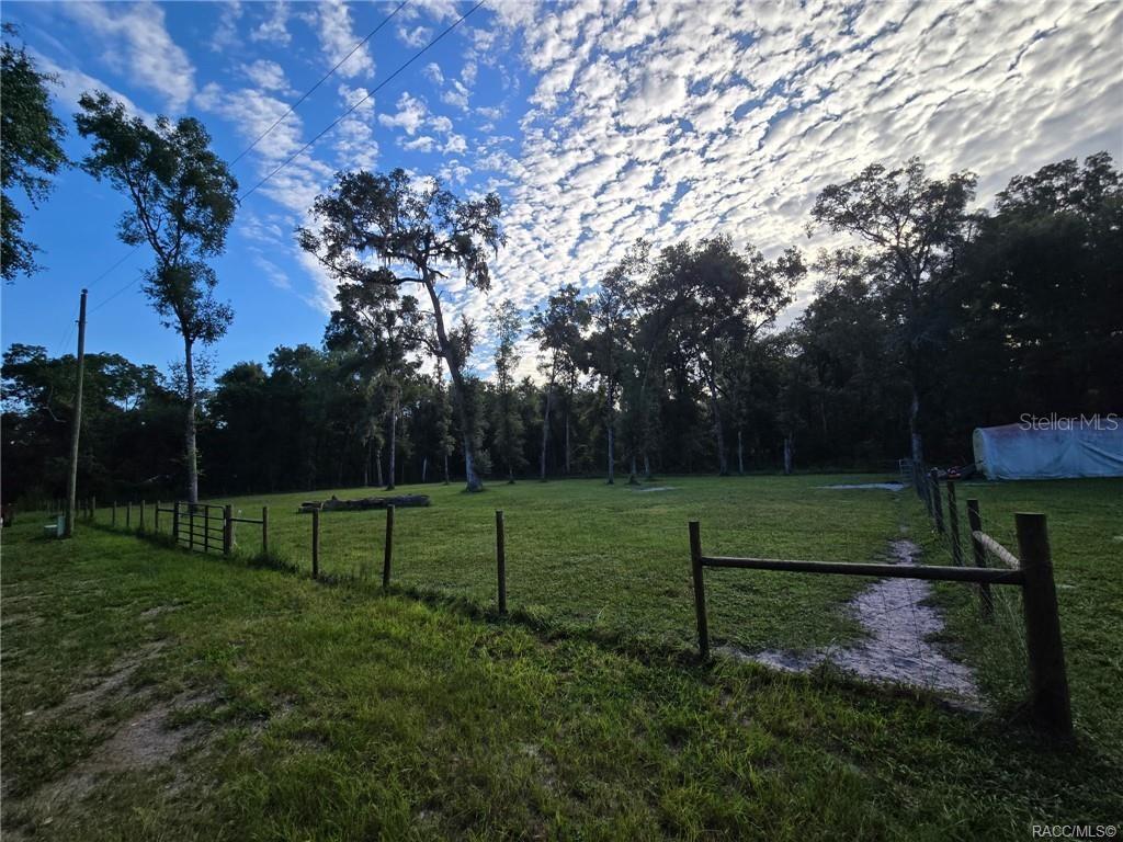 A fenced grassy pasture features scattered trees under a bright, cloudy sky — 4689 & 4713 S IRONWOOD POINT, INVERNESS, FL