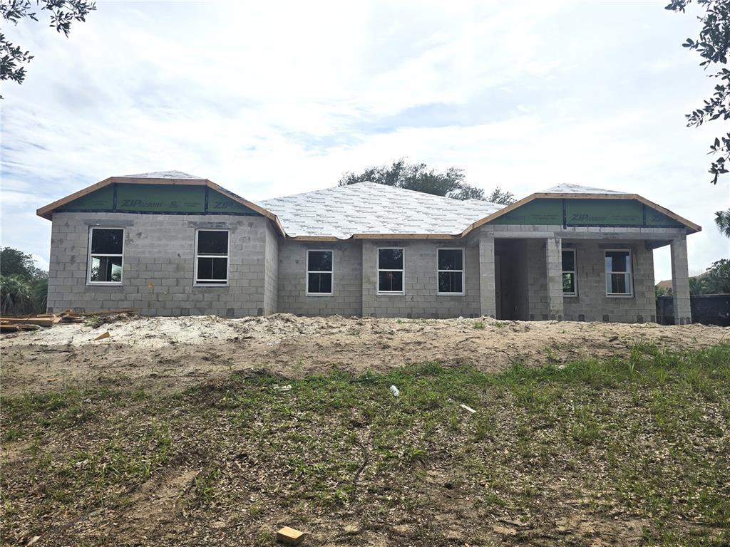 A modern kitchen features light gray cabinetry, a large white island with four stools, and stainless appliances — 17041 ROYAL PALM DRIVE, GROVELAND, FL