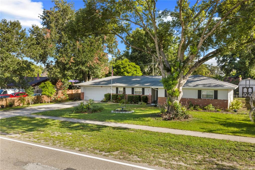 A single-story brick and siding house with a large tree in the front yard — 207 W WHEELER ROAD, SEFFNER, FL