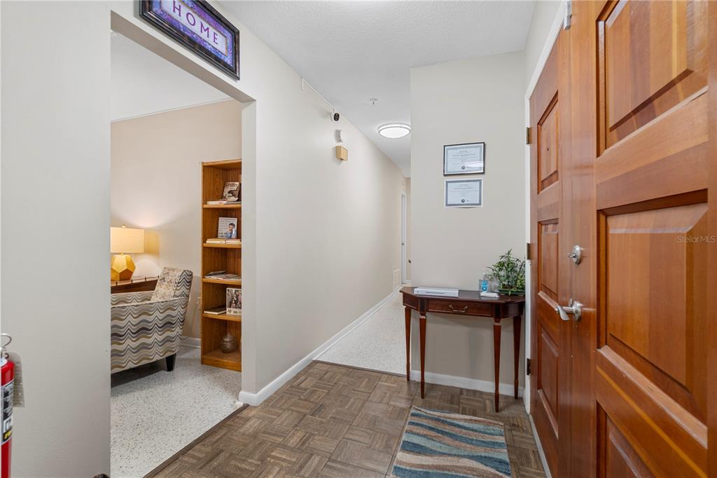 An entryway features wood-paneled double doors, a console table, and a view into a room — 207 W WHEELER ROAD, SEFFNER, FL