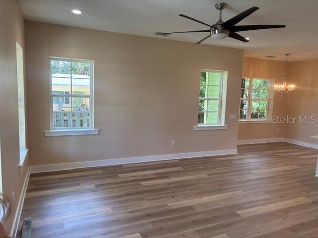 An open-concept kitchen and dining area features light wood flooring and white cabinetry — 1137 DOROTHY STREET, LAKELAND, FL