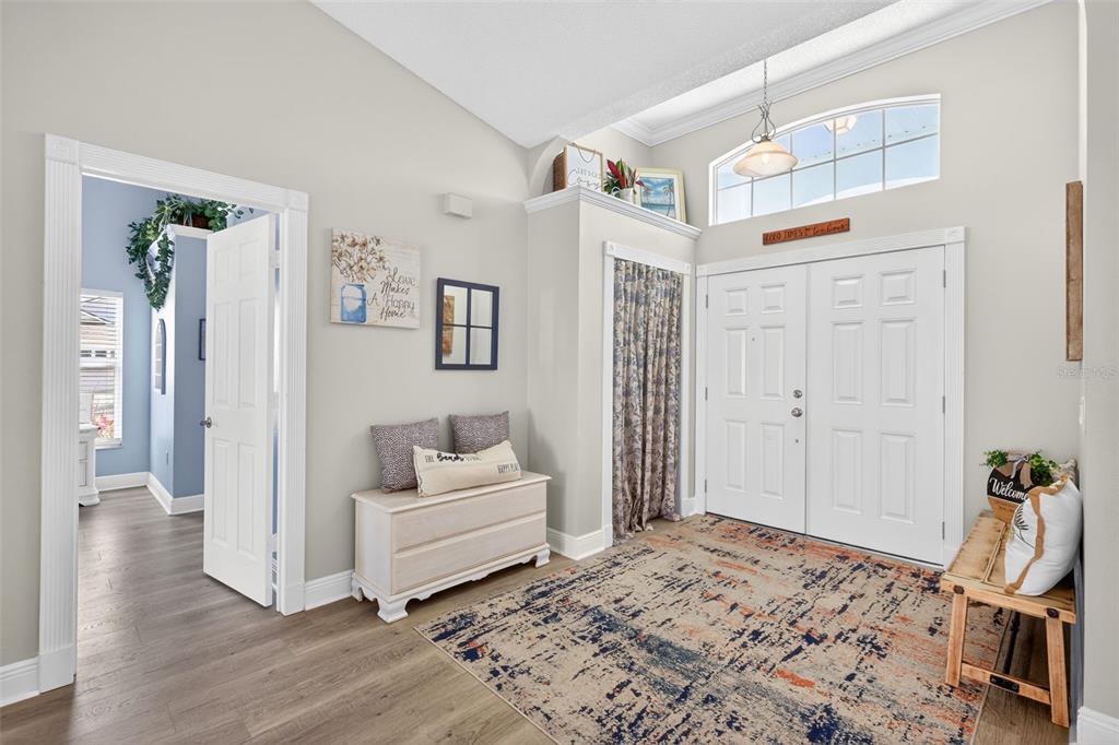 An entryway features a double front door, a patterned area rug, and a storage bench — 3907 57TH PLACE E, BRADENTON, FL