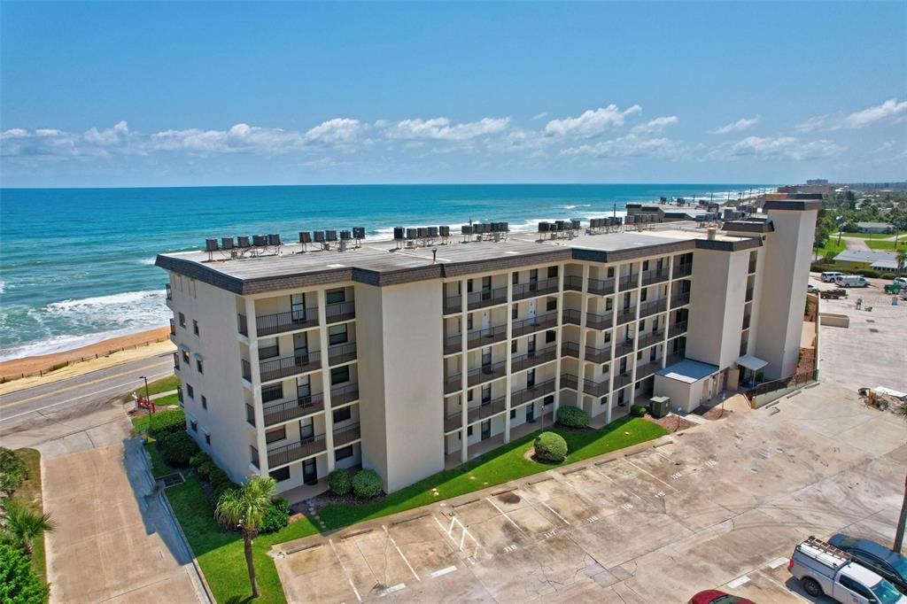 An aerial view of a multi-story beachfront apartment building with a parking lot — 2700 OCEAN SHORE BOULEVARD UNIT 315, ORMOND BEACH, FL