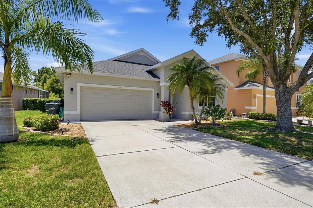 A single-story house with a concrete driveway, a two-car garage, and palm trees in front — 1796 SCARLETT AVENUE, NORTH PORT, FL