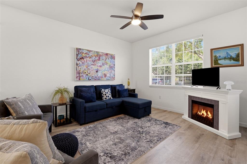 A living room features a blue sectional sofa, a fireplace, and a ceiling fan — 1796 SCARLETT AVENUE, NORTH PORT, FL