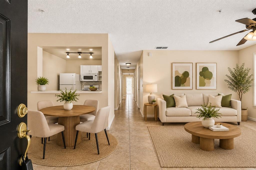 A view from an entryway into a living room and dining area with tile flooring — 2035 DIXIE BELLE DRIVE UNIT 2035M, ORLANDO, FL