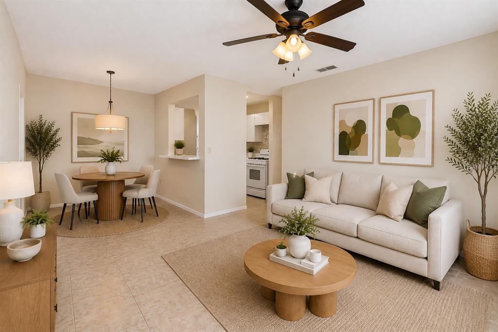 A living and dining area with a beige sofa, round wooden tables, and neutral decor — 2035 DIXIE BELLE DRIVE UNIT 2035M, ORLANDO, FL