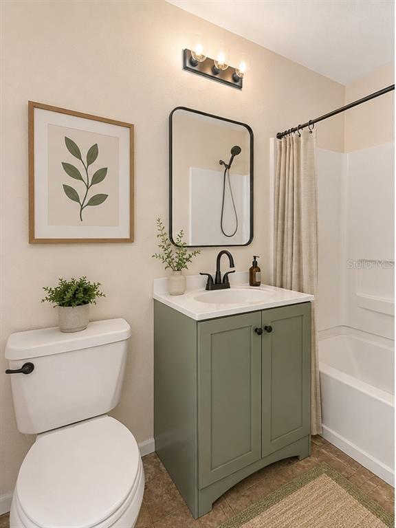 A bathroom features a sage green vanity, a rectangular mirror, and a shower-tub combination — 2035 DIXIE BELLE DRIVE UNIT 2035M, ORLANDO, FL