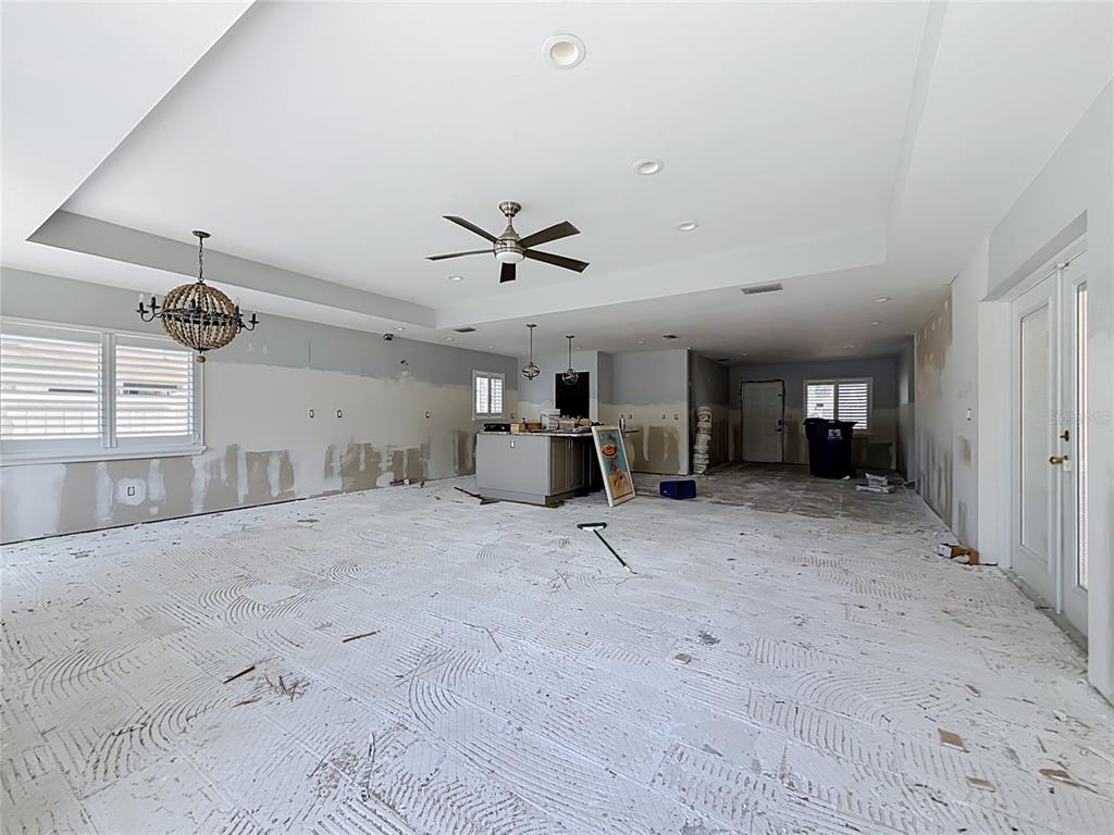 An unfinished open-concept living area with exposed drywall, a kitchen island, and a ceiling fan — 2010 BAYOU GRANDE BOULEVARD NE, ST PETERSBURG, FL