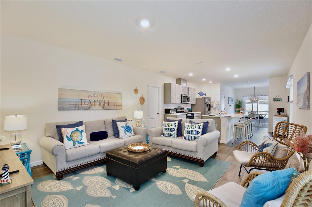 A living room with light-colored sofas, a dark ottoman, and a fish-patterned rug — 5356 HAYLOFT DRIVE, APOPKA, FL