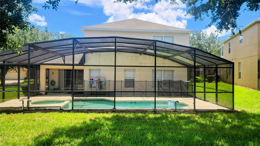 A screened-in swimming pool and spa area with a safety fence and patio — 8515 PALM HARBOR DRIVE, KISSIMMEE, FL