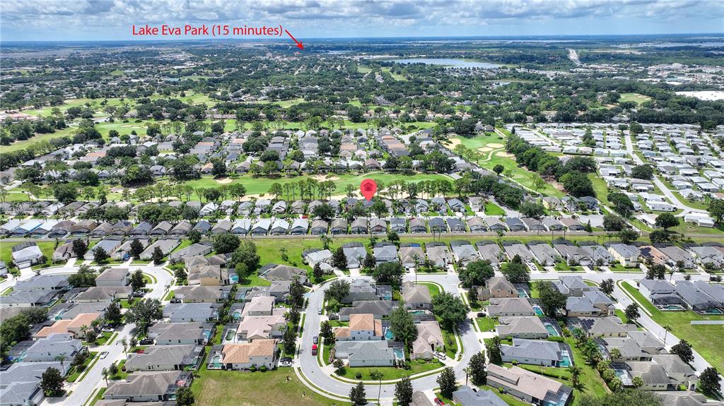 This aerial view shows a residential neighborhood with houses, streets, and a golf course — 2960 KOKOMO LOOP, HAINES CITY, FL