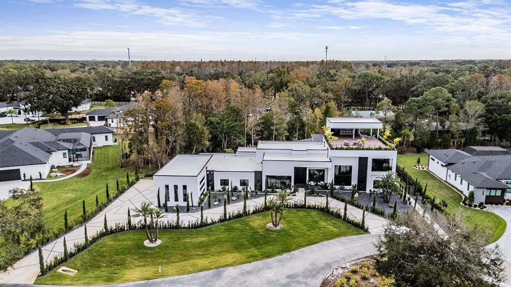 An aerial view of a modern white house with a flat roof and paved driveway — 309 GRANDE GROVE COURT, LUTZ, FL