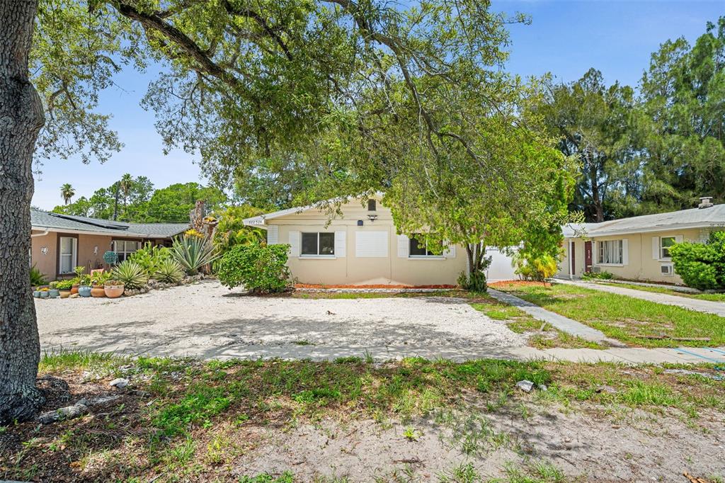 A single-story house with a gravel driveway and a large tree in the front yard — 522 FLORIDA AVENUE, CLEARWATER, FL