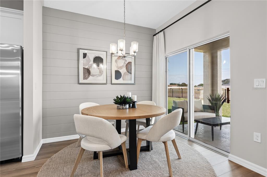 A dining area features a round wooden table, shiplap accent wall, and sliding glass patio doors — 118 ANCHOR LINE DRIVE, APOLLO BEACH, FL
