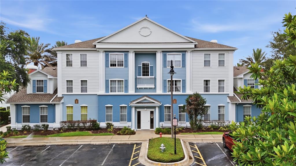 An open-concept kitchen and living area features a brick accent wall and a patio view — 7673 HERITAGE CROSSING WAY UNIT 102, REUNION, FL