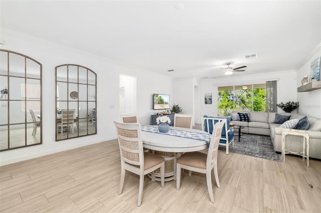 A dining area with a round table and chairs opens into a living room — 14281 17TH COURT E, PARRISH, FL