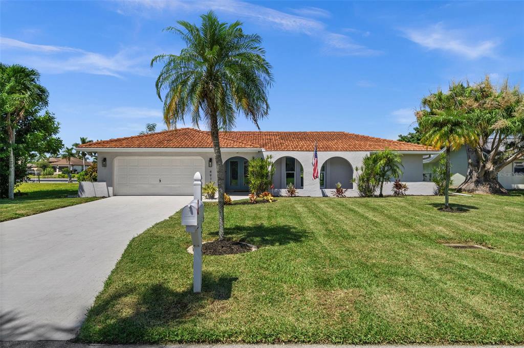 A single-story house with a tile roof, arched entryways, and a palm tree in the yard — 4914 SORRENTO COURT, CAPE CORAL, FL