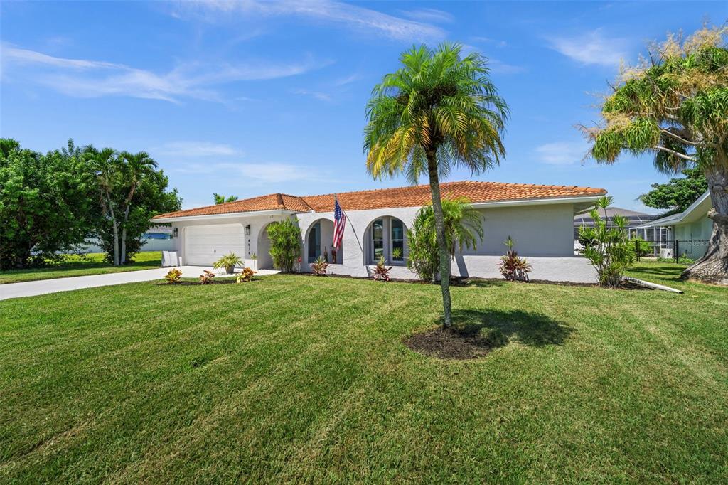 A single-story house with a white exterior, tile roof, and a palm tree in the yard — 4914 SORRENTO COURT, CAPE CORAL, FL