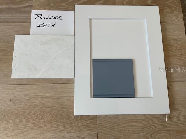 A sample board for a powder bath displays a white cabinet door, marble-look countertop, and blue tile — 1509 FLOWER DRIVE, SARASOTA, FL