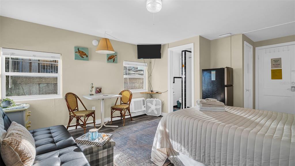 A studio apartment features a bed, a small dining table with two chairs, and a sofa — 483 E SHORE DRIVE UNIT D3, CLEARWATER BEACH, FL