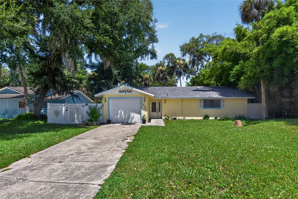 A single-story yellow house with a garage and a concrete driveway sits on a lawn — 408 PALM AVENUE, ORMOND BEACH, FL