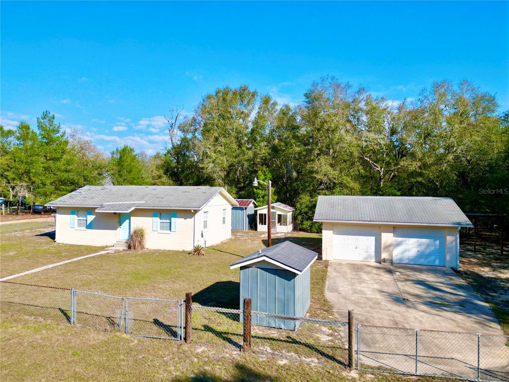 An exterior view of a single-story house, a detached garage, and a small storage shed — 600 WAKULLA STREET, FLORAHOME, FL