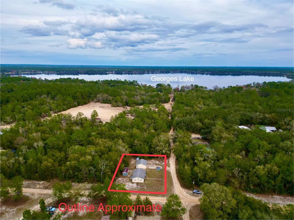An aerial view shows a house with a red outline situated on a wooded lot — 600 WAKULLA STREET, FLORAHOME, FL