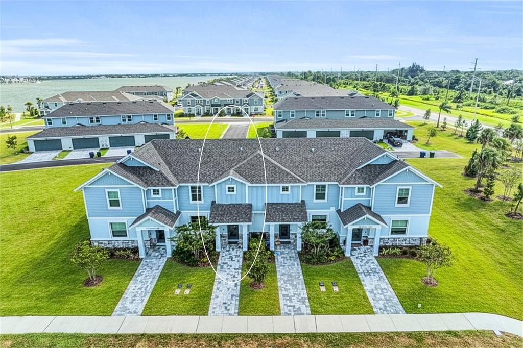 An aerial view of a blue multi-unit townhouse building with a circled front entrance — 1741 CLEAT LANE, SARASOTA, FL