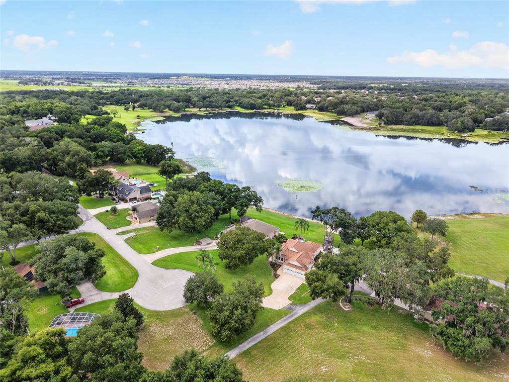 An aerial view shows several houses situated along the shore of a large lake — 1833 SHORE LINE DRIVE, LEESBURG, FL